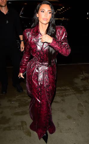 Kardashian enjoyed NYFW in a long red snakeskin coat