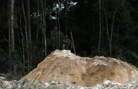 An Ibama specialised inspector takes a position at an illegal gold mine during an operation conducted by agents of the Brazilian Institute for the Environment and Renewable Natural Resources, or Ibama, in national parks near Novo Progresso, southeast of Para state, Brazil, November 5, 2018. REUTERS/Ricardo Moraes