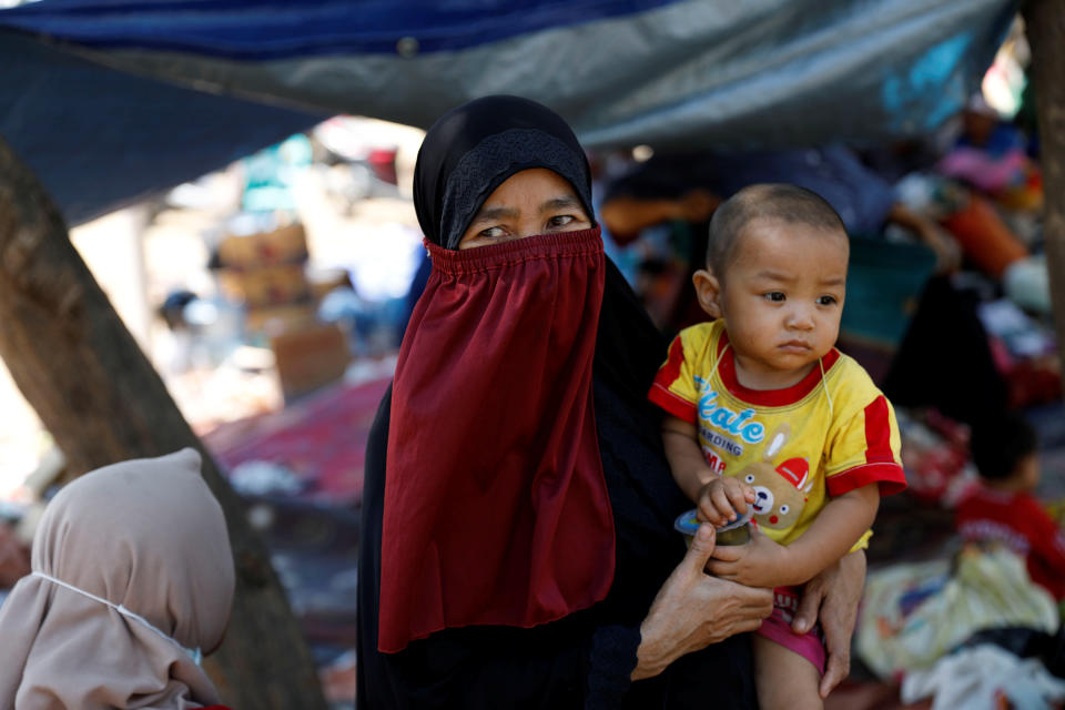 <p>A villager holds her child as she stands in a temporary shelter after an earthquake hit Lombok island in Pamenang, Indonesia, Aug. 6, 2018. (Photo: Beawiharta/Reuters) </p>