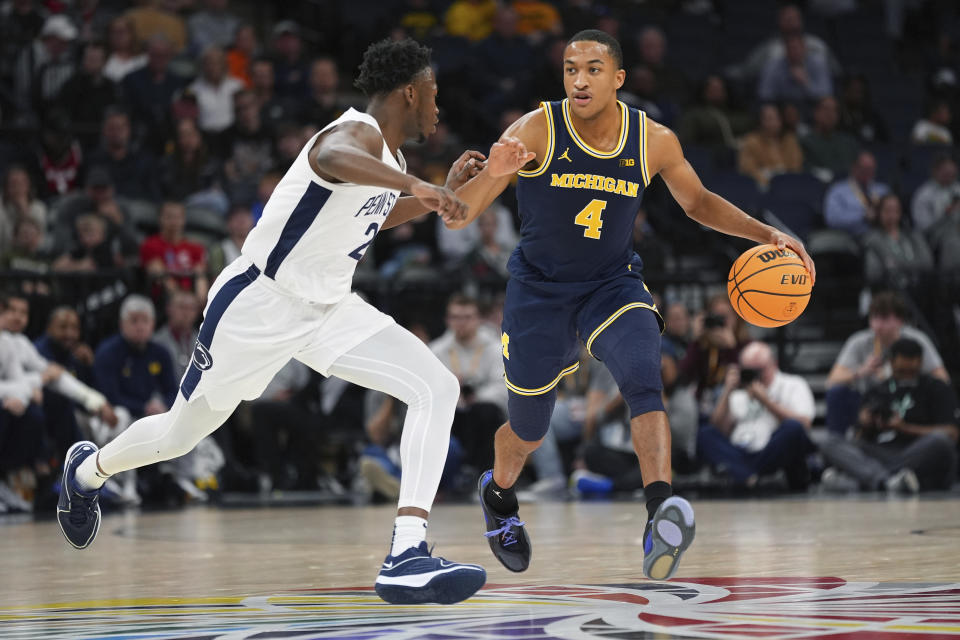 Michigan guard Nimari Burnett (4) drives against Penn State guard D'Marco Dunn (2) during the first half of an NCAA college basketball game in the first round of the Big Ten Conference men's tournament Wednesday, March 13, 2024, in Minneapolis. (AP Photo/Abbie Parr)