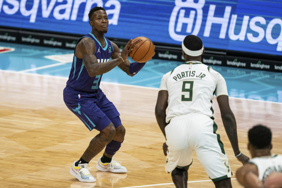 Charlotte Hornets guard Terry Rozier (3) shoots while guarded by Milwaukee Bucks center Bobby Portis (9) during the first half of an NBA basketball game in Charlotte, N.C., Saturday, Jan. 30, 2021. (AP Photo/Jacob Kupferman)