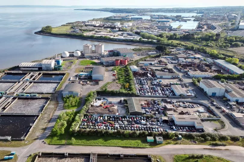 The site, next to the water, as seen from above with the vats of sewage, balloons for biogas, and car parks visible.