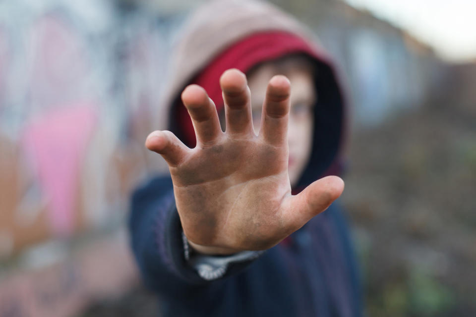 A kid holding his hand up to the camera