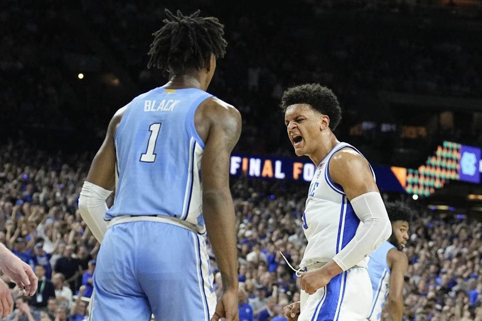 Duke forward Paolo Banchero, right, celebrates after scoring as North Carolina guard Leaky Black looks on during the first half of a college basketball game in the semifinal round of the Men's Final Four NCAA tournament, Saturday, April 2, 2022, in New Orleans. (AP Photo/Brynn Anderson)