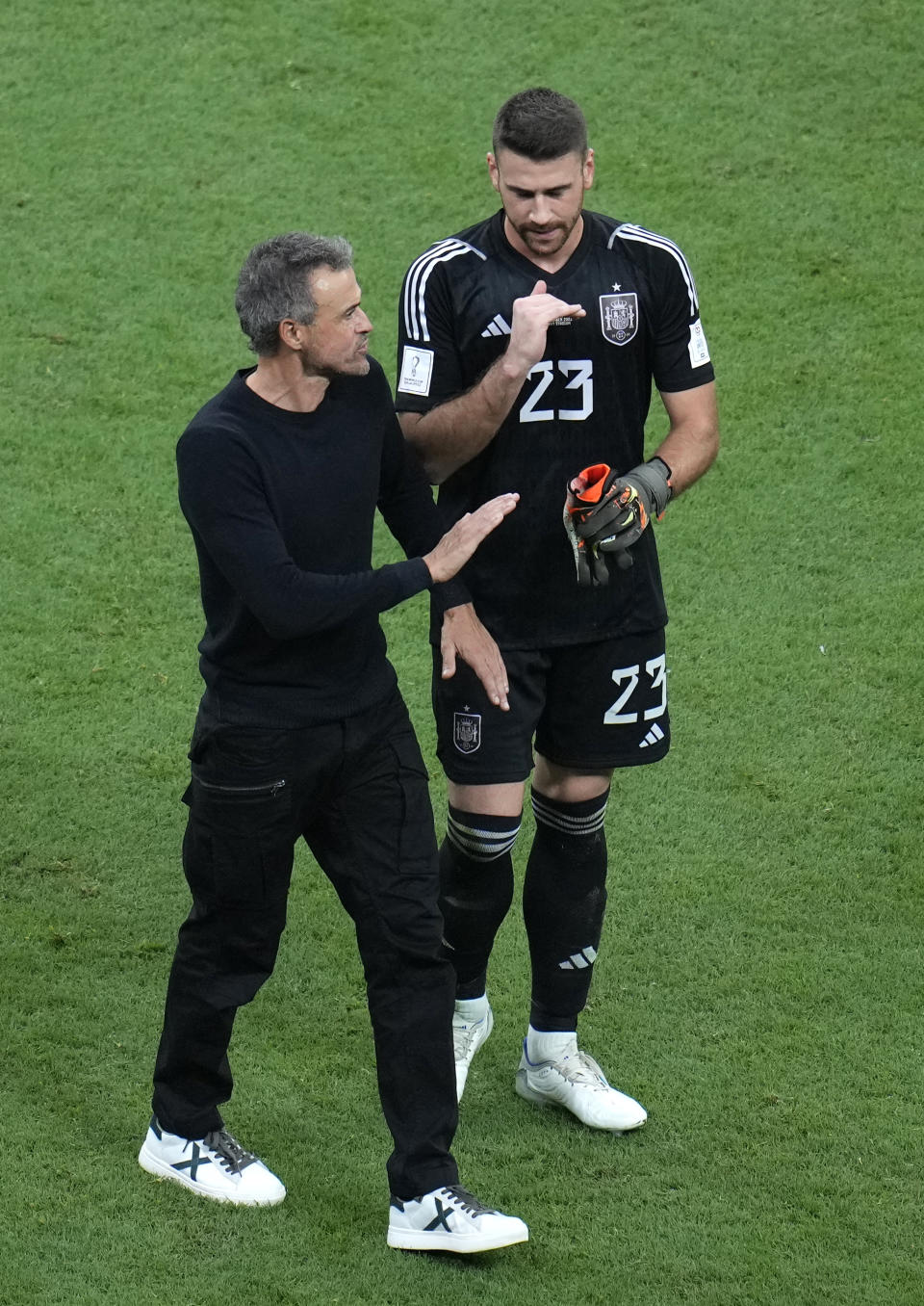 Spain's head coach Luis Enrique leaves the field with Spain's goalkeeper Unai Simon at the end of the World Cup group E soccer match between Spain and Germany, at the Al Bayt Stadium in Al Khor, Qatar, Sunday, Nov. 27, 2022. (AP Photo/Ricardo Mazalan)