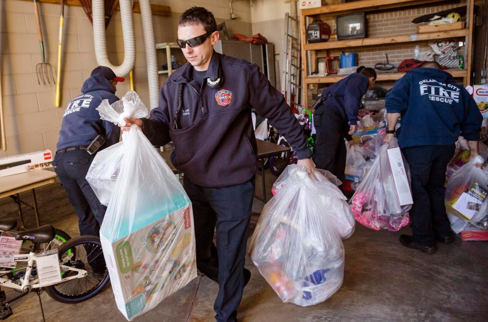 Cpl. Shay James loads bags of toys that members of Oklahoma City Fire Department Station No. 1 had purchased for foster care children in Oklahoma City.