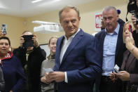 Poland's main opposition leader Donald Tusk prepares to cast his ballot during parliamentary elections in Warsaw, Poland, Sunday, Oct. 15, 2023. The outcome of Sunday's election will determine whether the right-wing Law and Justice party will win an unprecedented third straight term or whether a combined opposition can win enough support to oust it. (AP Photo/Petr David Josek)
