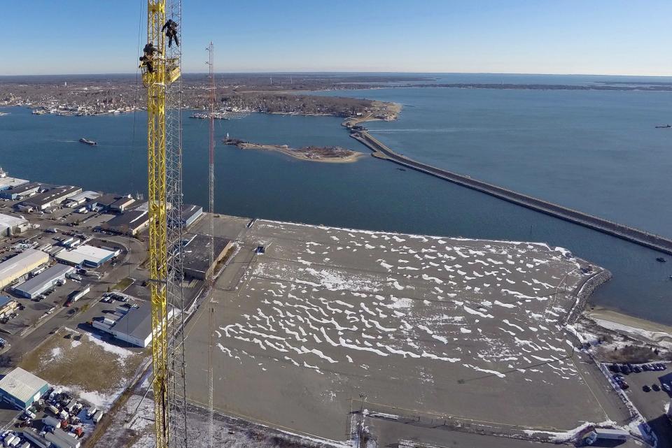 The Marine Commerce Terminal can be seen below as workmen install an antenna overlooking New Bedford Harbor and the hurricane barrier in the background. [ PETER PEREIRA/STANDARD-TIMES FILE/SCMG ]