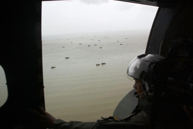 Crew of an Indonesian navy aircraft search for missing AirAsia Flight QZ8501 in Karimata Strait on January 3, 2014