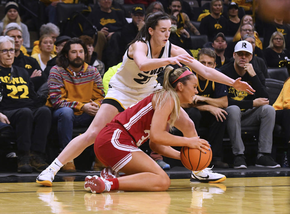 Indiana guard Sydney Parrish (33) tries to recover the ball under pressure from Iowa guard Caitlin Clark (22) during the first half of an NCAA college basketball game, Saturday, Jan. 13, 2024, in Iowa City, Iowa. (AP Photo/Cliff Jette)