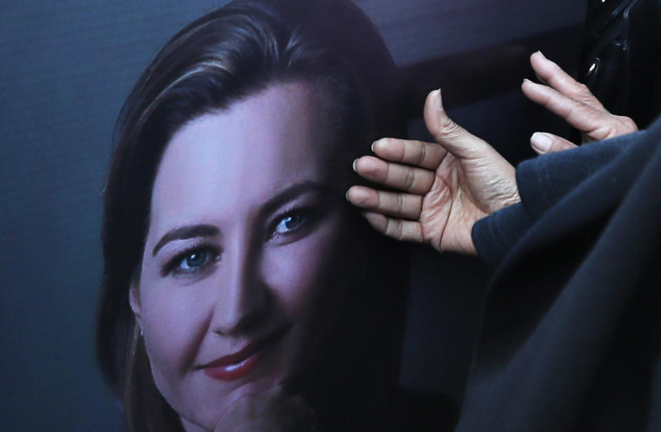 Women touch the a portrait showing Puebla state Gov. Martha Erika Alonso during a farewell ceremony in Puebla, southeast of Mexico City, on Tuesday, Dec. 25, 2018. Mexico has invited experts from the U.S. National Transportation Safety Board to investigate a helicopter crash that killed the governor, her husband, two pilots and a third passenger. (AP Photo/Marco Ugarte)