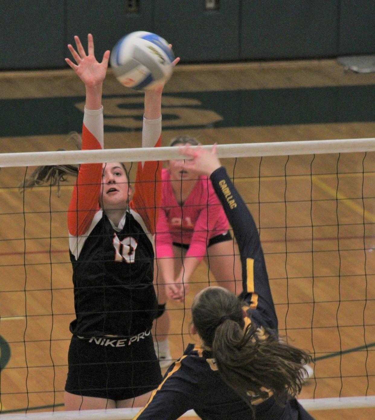 Cheboygan senior Mya Collino (left) goes up for a block during a regional championship clash against Cadillac in November. Collino will continue her volleyball career as a member of the North Central Michigan College women's volleyball team next season.