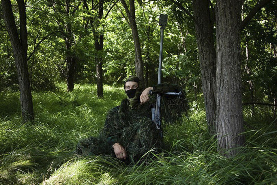 In this photo released by the Russian Defense Ministry Press Service on Thursday, Aug. 10, 2023, a Russian sniper sits at his position toward Ukrainian positions at the Zapad (West) group of Russian troops at an undisclosed location of Ukraine. (Russian Defense Ministry Press Service via AP)