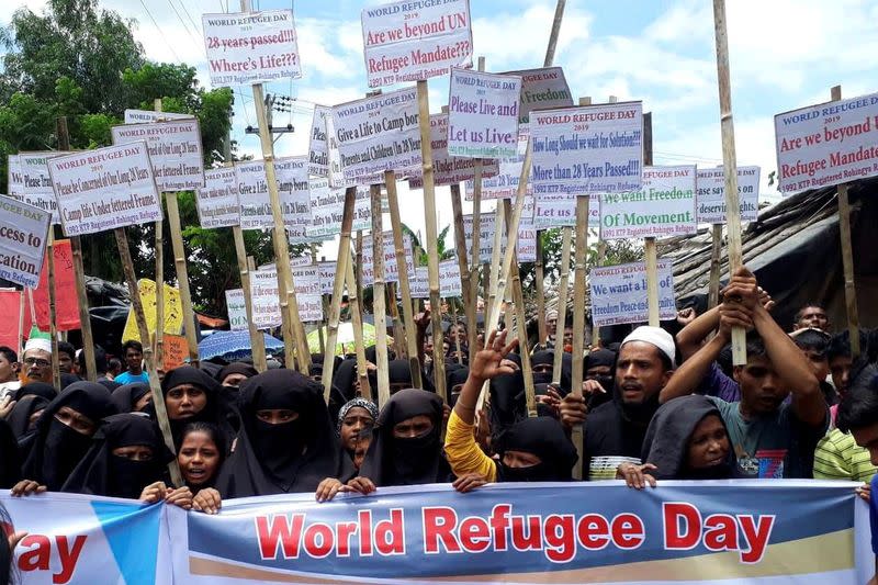 FILE PHOTO: Rohingya refugees hold placards as they participate in a rally to observe World Refugee Day at the Rohingya refugee camp in Cox's Bazar