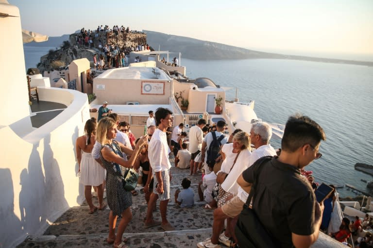 Turistas esperan la puesta de sol en el pueblo de Oia, en la isla griega de Santorini, el 20 de julio de 2024 (Aris Oikonomou)