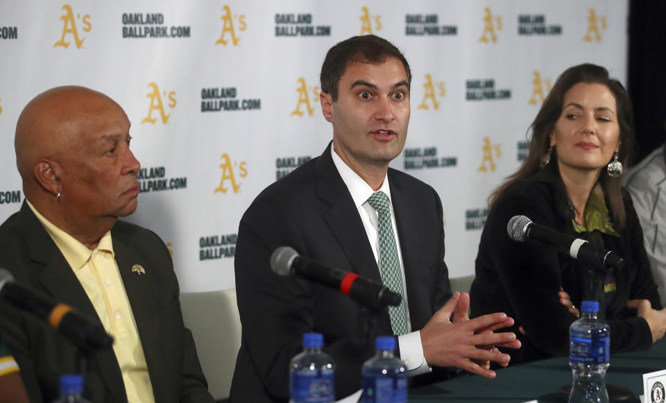 FILE - Oakland Athletics President Dave Kaval, center, speaks beside Oakland Mayor Libby Schaaf, right, and Ces Butner, President of the Board of Port Commissioners, during a baseball news conference in Oakland, Calif., in this Wednesday, Nov. 28, 2018, file photo. Major League Baseball instructed the Athletics to explore relocation options as the team tries to secure a new ballpark it hopes will keep the club in Oakland in the long term. MLB released a statement Tuesday, May 11, 2021, expressing its longtime concern that the current Coliseum site is “not a viable option for the future vision of baseball.” (AP Photo/Ben Margot, FIle)