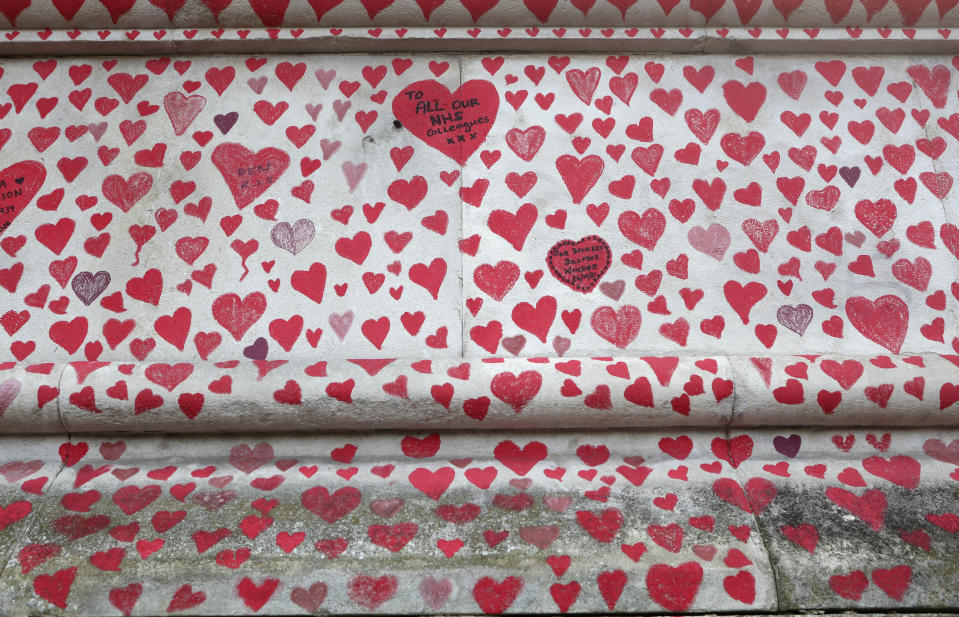 A close up of the hearts on the 'The National COVID Memorial Wall' on the south bank of the Thames in front of St. Thomas' hospital and opposite the House of Parliament in London, Sunday April 4, 2021. Hearts are being drawn onto the wall in memory of the many thousands of people who have died in the UK from coronavirus, with organizers hoping to reach their target of 150,000 hearts by the middle of next week. (AP Photo/Tony Hicks)