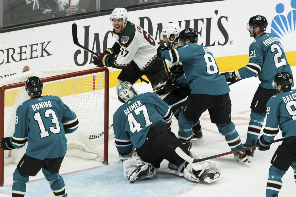 Arizona Coyotes left wing Lawson Crouse (67) scores a goal against San Jose Sharks goaltender James Reimer (47) during the third period of an NHL hockey game Sunday, March 20, 2022, in San Jose, Calif. The Sharks won 4-2. (AP Photo/John Hefti)