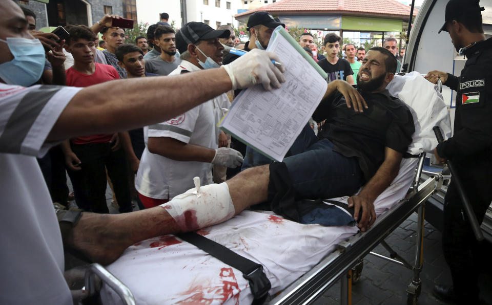 Medics move a wounded youth, who was shot by Israeli troops in his leg during a protest at the Gaza Strip's border with Israel, into the treatment room of Shifa hospital in Gaza City, Saturday, Aug. 21, 2021. (AP Photo/Abdel Kareem Hana)