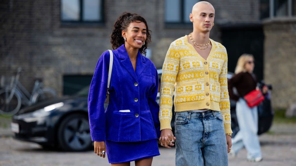 a couple holding hands at copenhagen fashion week