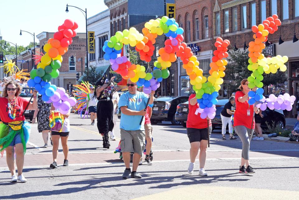 Marchers in the first-ever Mid-MO PrideFest parade in downtown Columbia hold balloon letters Sunday that spell "love."