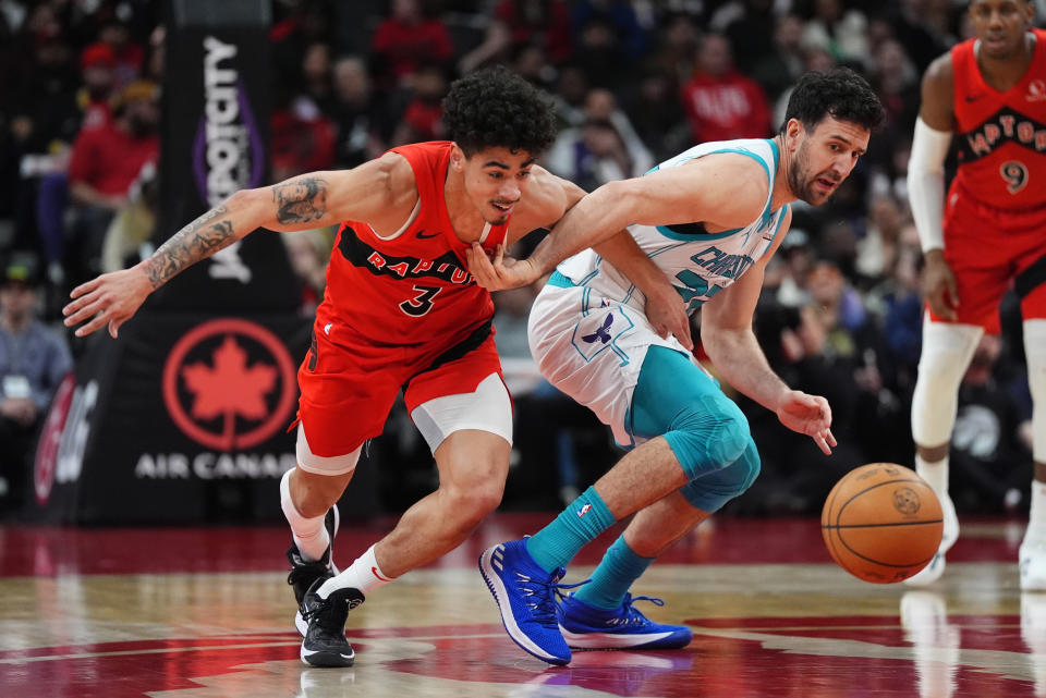 Charlotte Hornets' Vasilije Micić, right, and Toronto Raptors guard D.J. Carton (3) battle for a loose ball during the second half of an NBA basketball game in Toronto on Sunday, March 3, 2024. (Frank Gunn/The Canadian Press via AP)