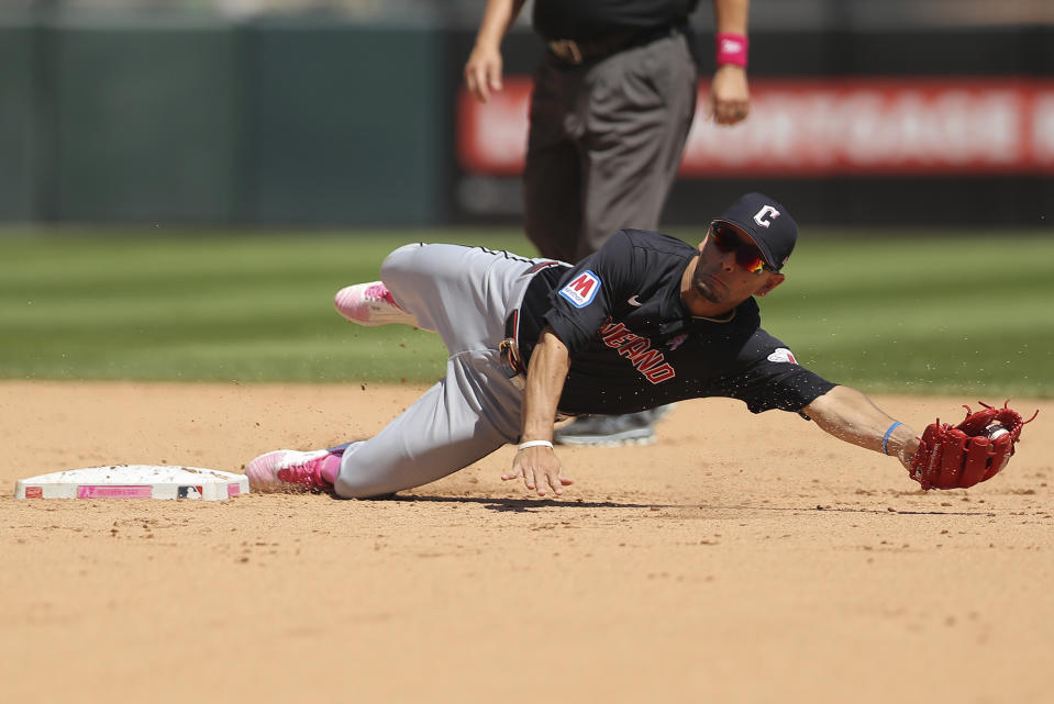 Cleveland Guardians' Andrés Giménez (0) dives to catch the ball overthrown by Cleveland Guardians starting pitcher Logan Allen during the fourth inning of a baseball game against the Chicago White Sox, Sunday, May 12, 2024, in Chicago. (AP Photo/Melissa Tamez)