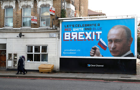 People walk past a billboard poster in London, Britain, November 8, 2018. REUTERS/Peter Nicholls