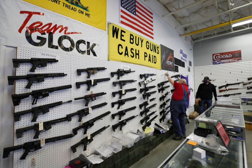 Workers arrange AR-15 style rifles on a wall that are for sale at Davidson Defense in Orem, Utah on February 4, 2021. - Gun merchants sold more than 2 million firearms in January, a 75% increase over the estimated 1.2 million guns sold in January 2020, according to the National Shooting Sports Federation, a firearms industry trade group. The FBI said it conducted a record 4.3 million background checks in January. If that pace continues, the bureau will complete more than 50 million gun-related background checks by the end of the year, shattering the current record set in 2020, according to a new report from Bespoke Investment Group. (Photo by GEORGE FREY / AFP) (Photo by GEORGE FREY/AFP via Getty Images)