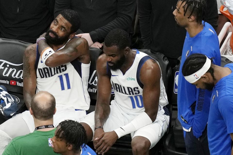 Dallas Mavericks' Kyrie Irving (11) and Tim Hardaway Jr. (10) sit on the bench during a timeout in the second half of Game 5 of the NBA basketball finals against the Boston Celtics, Monday, June 17, 2024, in Boston. (AP Photo/Michael Dwyer)