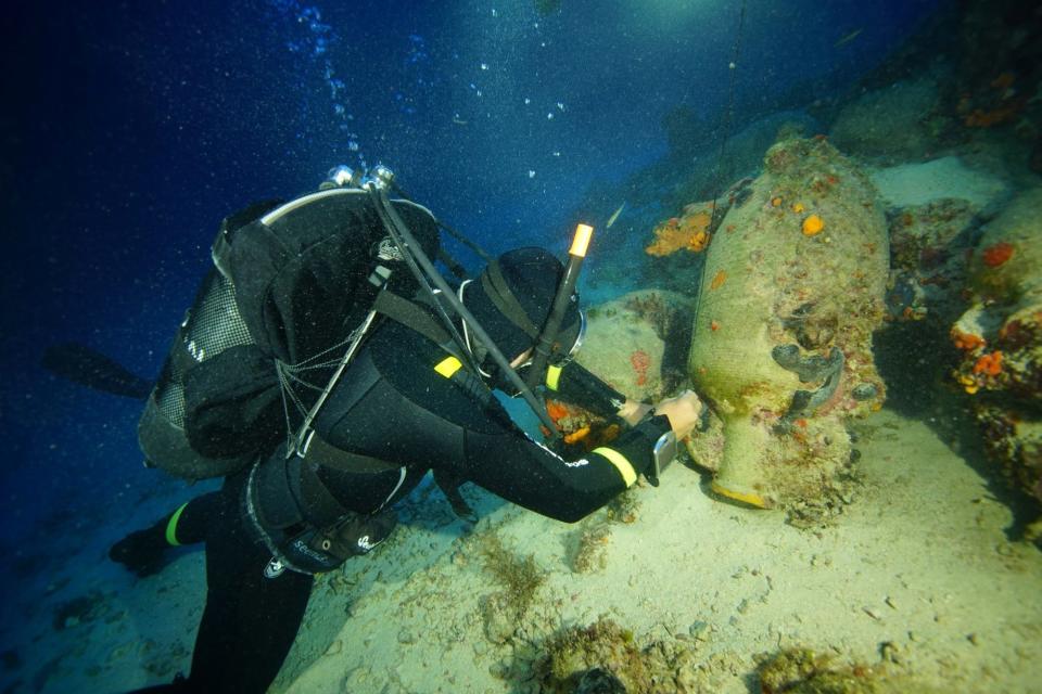 This undated handout photo provided by the Greek Culture Ministry on Monday, Oct. 15 , 2018, divers inspect items on the seabed from an ancient shipwreck discovered off the island of Fourni. Greece's culture ministry says a Greek-U.S. team has located traces of five more ancient shipwrecks in the eastern Aegean Sea, raising to 58 the number of wrecks located since 2015 around Fourni, a notoriously dangerous point on the ancient shipping route. (Greek Culture Ministry via AP)