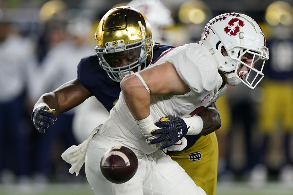 Stanford running back Casey Filkins, right, fumbles the ball next to Notre Dame safety Ramon Henderson during the first half of an NCAA college football game in South Bend, Ind., Saturday, Oct. 15, 2022. (AP Photo/Nam Y. Huh)