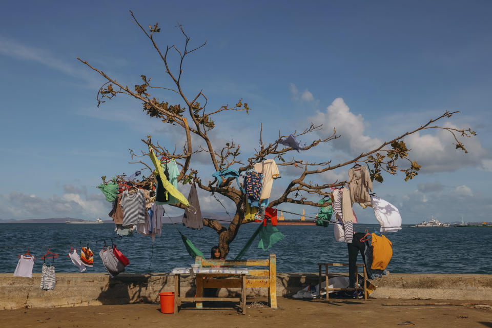 In this photo provided by Greenpeace, clothes are left to dry on a typhoon damaged tree in Surigao City, southern Philippines on Monday Dec. 20, 2021. The governor of a central Philippine province devastated by Typhoon Rai last week pleaded on radio Tuesday for the government to quickly send food and other aid, warning that without outside help, army troops and police forces would have to be deployed to prevent looting amid growing hunger. (Jilson Tiu/Greenpeace via AP)