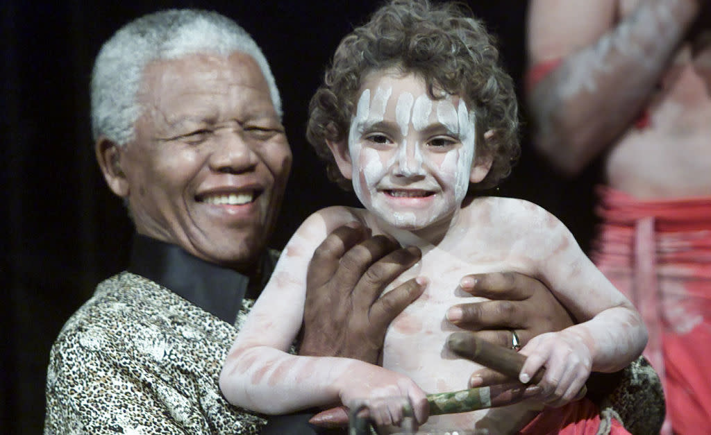 The late Nelson Mandela with Yorta Yorta kid, Daniel Guinane, 4, after a welcoming dance at a lunch for World Reconciliation Day in Melbourne in 2000. (Credit: Jason South/Fairfax Media via Getty Images)