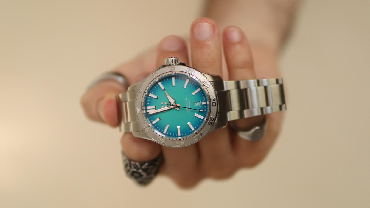  The Christopher Ward C60 Atoll 300 in Blue held in a hand. 