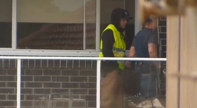 Officers raiding the home on Wattle Street, Punchbowl. Photo: 7 News