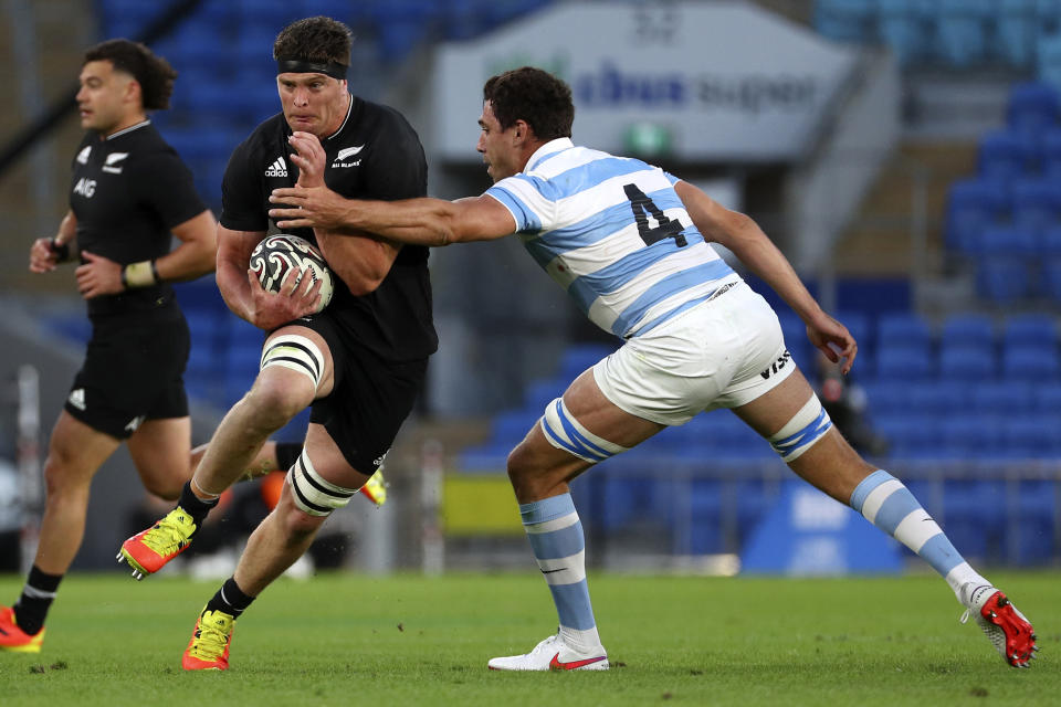 New Zealand's Scott Barrett, center, runs past Argentina's Guido Petti during their Rugby Championship match on Sunday, Sept. 12, 2021, on the Gold Coast, Australia. (AP Photo/Tertius Pickard)