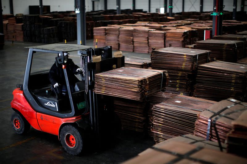 FILE PHOTO: FILE PHOTO: A worker loads copper cathodes into a warehouse near Yangshan Deep Water Port, south of Shanghai, China