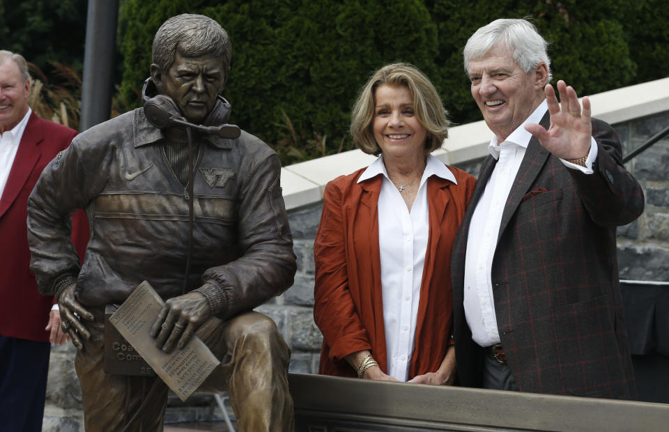 Former Virginia Tech head football coach Frank Beamer, right, and his wife Cheryl, pose next to a statue dedicated to him in front of Lane Stadium in Blacksburg, Va., Saturday, Oct. 6, 2018. (AP Photo/Steve Helber)