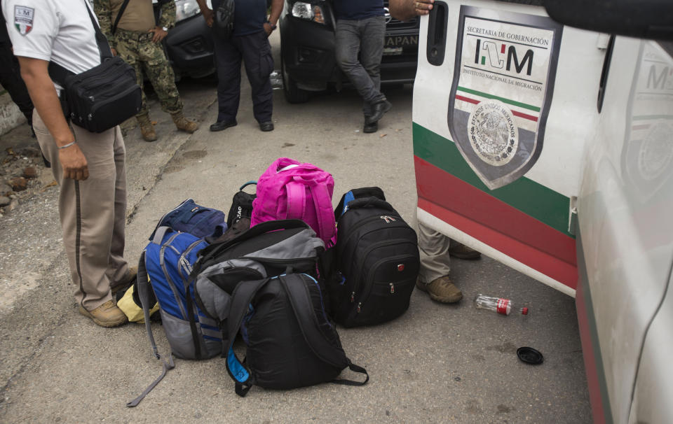 Bags belonging to migrants without legal permission to be in Mexico sit on the street next to an immigration van parked outside an Attorney General before migrants sitting inside the van are transported to Tapachula from Arriaga, Mexico, Sunday, June 23, 2019. Mexico has completed its deployment of 6,000 National Guard agents to help control the flow of migrants headed toward the U.S. and filled immigration agency posts to regulate border crossings, the government said Friday. (AP Photo/Oliver de Ros)