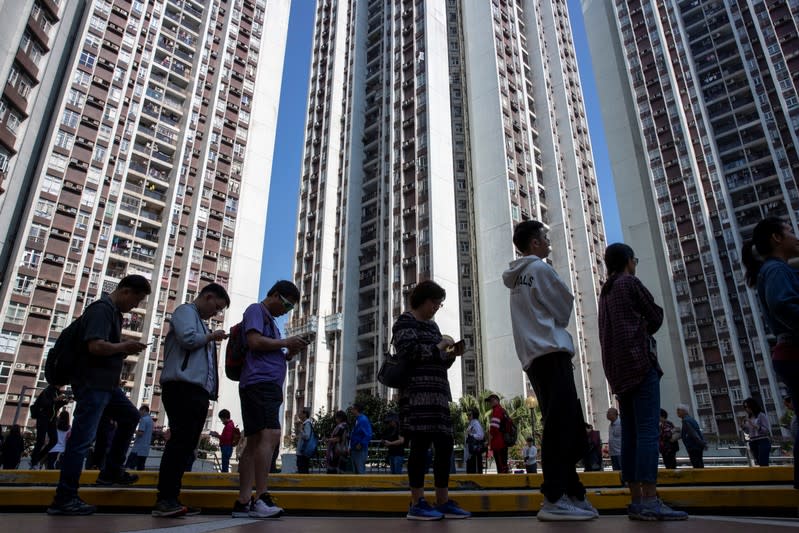 Voters queue to vote at a polling station during district council local elections in Hong Kong