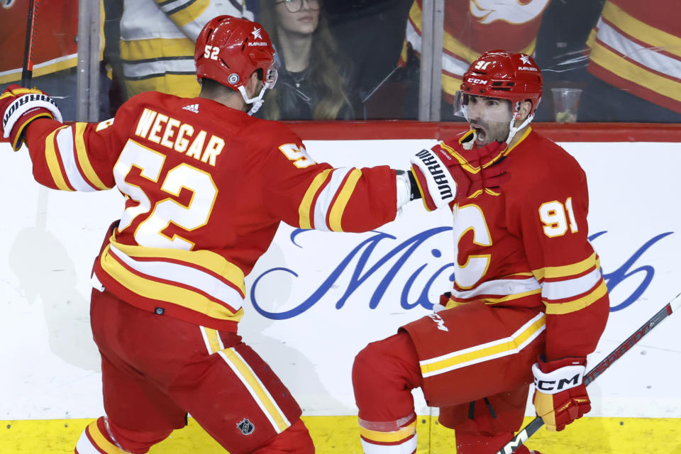 Calgary Flames' Nazem Kadri, right, celebrates his overtime goal against the Boston Bruins with MacKenzie Weegar during an NHL hockey game Thursday, Feb. 22, 2024, in Calgary, Alberta. (Larry MacDougal/The Canadian Press via AP)