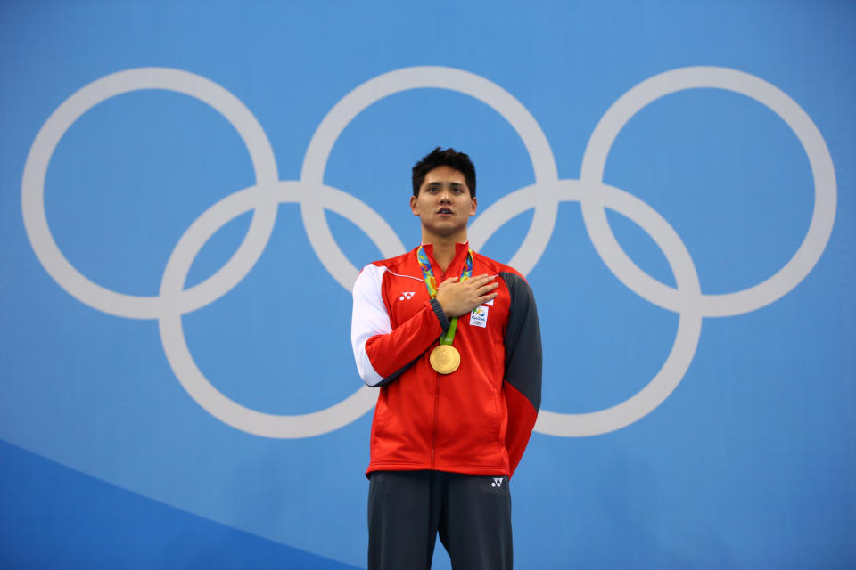 Joseph Schooling on the winner's podium after winning the gold medal in the men's 100m butterfly at the 2016 Rio de Janeiro Olympics Games.