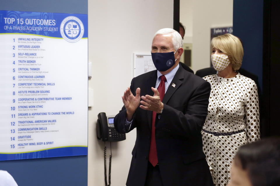 Vice President Mike Pence and Education Secretary Betsy DeVos greet students in a fourth grade classroom at Thales Academy that reopened to students in Apex, N.C., Wednesday, July 29, 2020. (AP Photo/Gerry Broome)