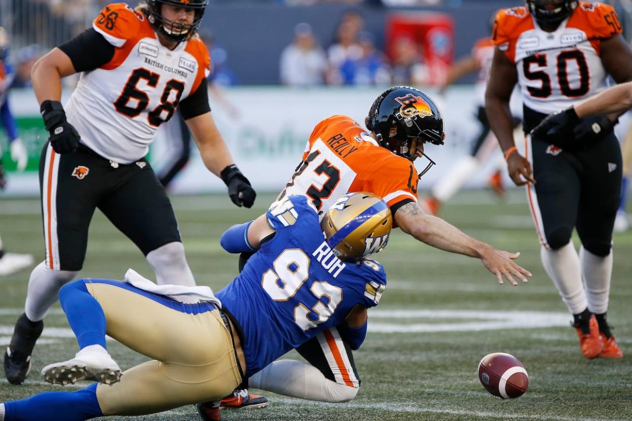 Winnipeg Blue Bomber Craig Roh (93) sacks B.C. Lions quarterback Mike Reilly (13) and forces a fumble during the first half of CFL action in Winnipeg on Aug. 15, 2019. Defensive lineman Roh, who won a Grey Cup with the Winnipeg Blue Bombers in 2019, has died. (John Woods/The Canadian Press - image credit)