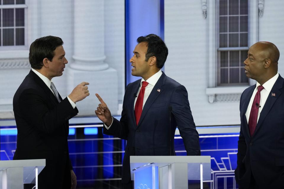 Republican presidential candidate businessman Vivek Ramaswamy talks with Florida Gov. Ron DeSantis as Sen. Tim Scott, R-S.C., listens during a Republican presidential primary debate hosted by NBC News, Wednesday, Nov. 8, 2023, at the Adrienne Arsht Center for the Performing Arts of Miami-Dade County in Miami. | Rebecca Blackwell, Associated Press