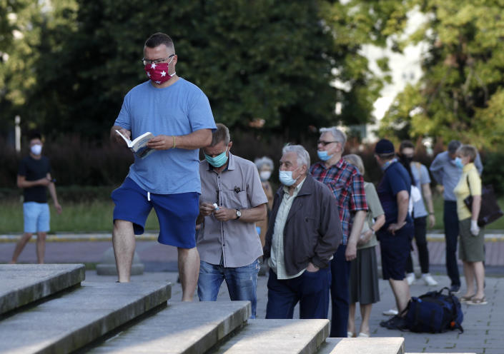 People, keeping social distancing, wait in line to cast their vote in presidential election in Warsaw, Poland, Sunday, June 28, 2020. The election will test the popularity of incumbent President Andrzej Duda who is seeking a second term and of the conservative ruling party that backs him. (AP Photo/Petr David Josek)