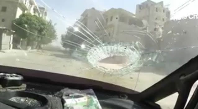 A large piece of debris leaves a significant hole in the windshield of the vechicle. Source: Syria Charity/Facebook.