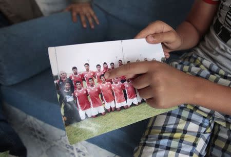 Younger brother of Nidhal Selmi, a youth who was killed during during fighting in Syria, points at Nidhal on a photo during an interview with Reuters in Sousse November 10, 2014. REUTERS/Zoubeir Souissi