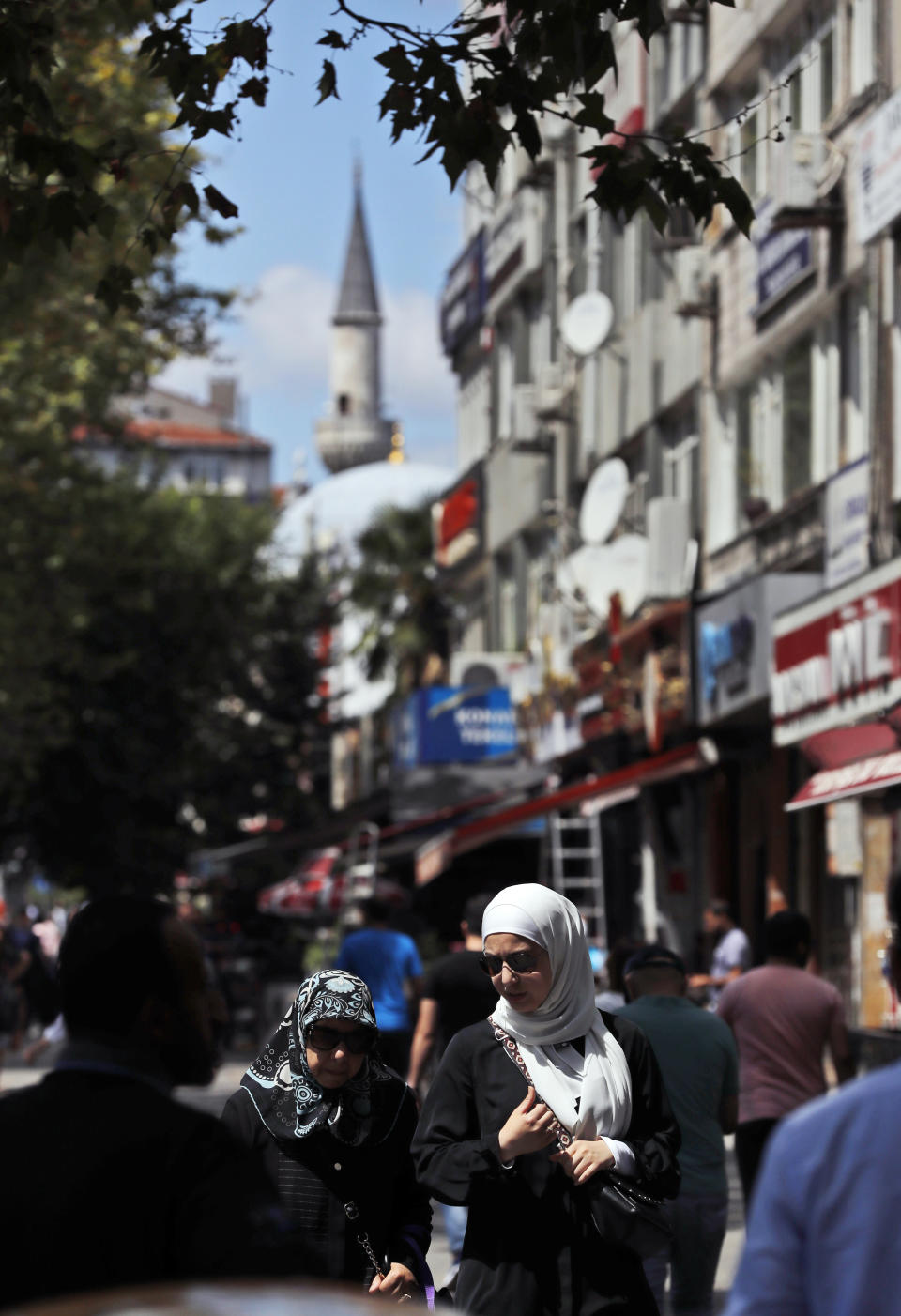 In this photo taken on Tuesday, Aug. 20, 2019, people walk in the Istanbul neighborhood of Aksaray, where many Syrians live. Syrians say Turkey has been detaining and forcing some Syrian refugees to return back to their country the past month. The expulsions reflect increasing anti-refugee sentiment in Turkey, which opened its doors to millions of Syrians fleeing their country's civil war. (AP Photo/Lefteris Pitarakis)